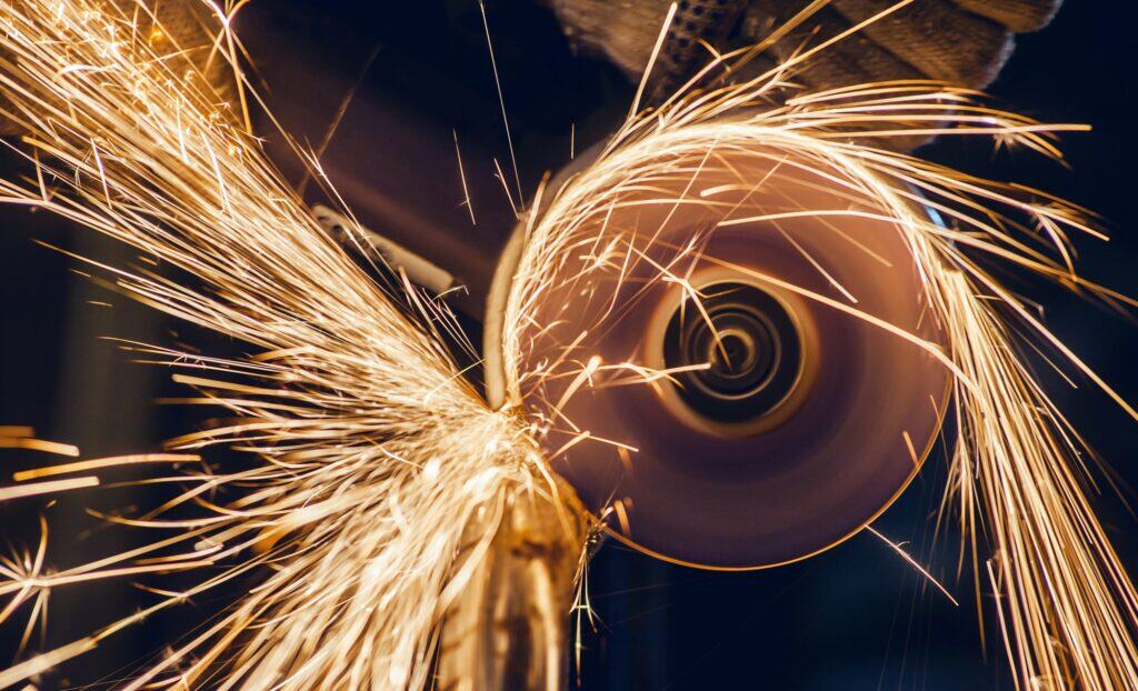 a man cuts metal with a power tool. Lots of sparks